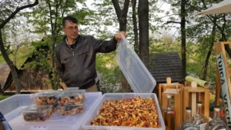 Valerian Hagiu din Valenii de Munte, cu tuica batrana si fructe deshidratate, la targul traditional de la Muzeul Satului